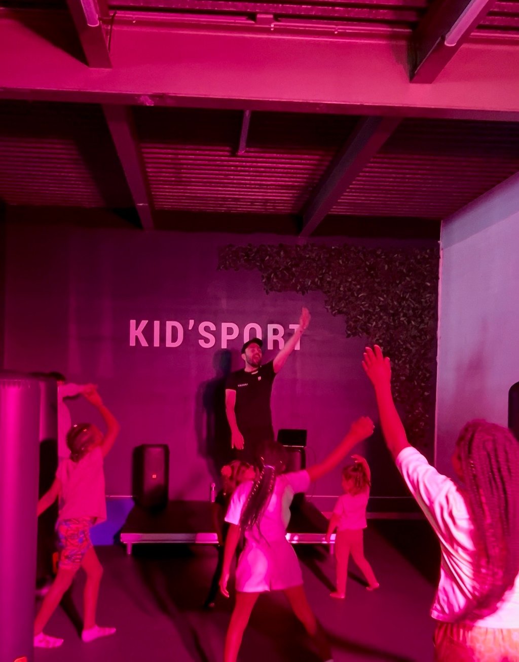 Coach sportif qui donne un cours de zumba a un groupe d'enfants