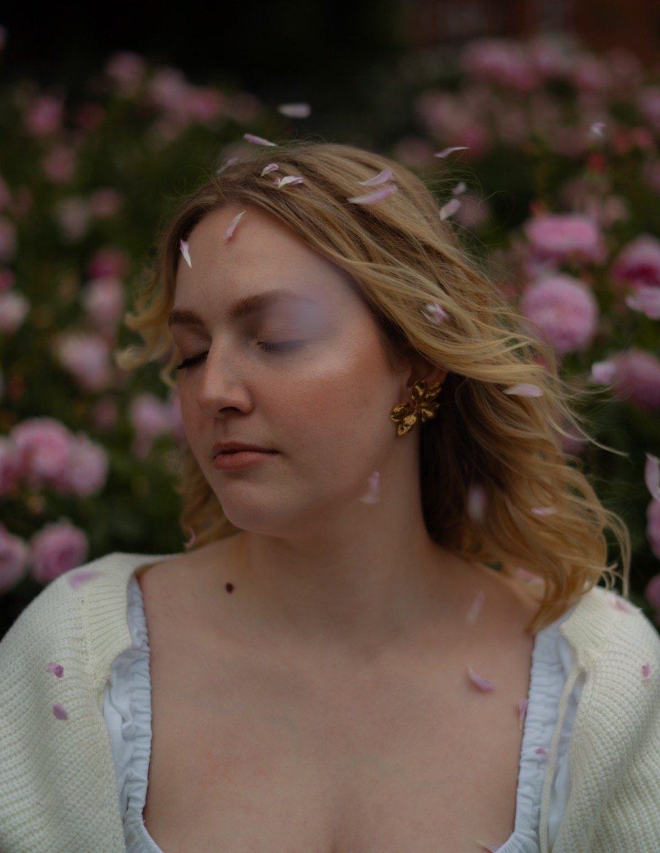woman with closed eyes and rose petals around her