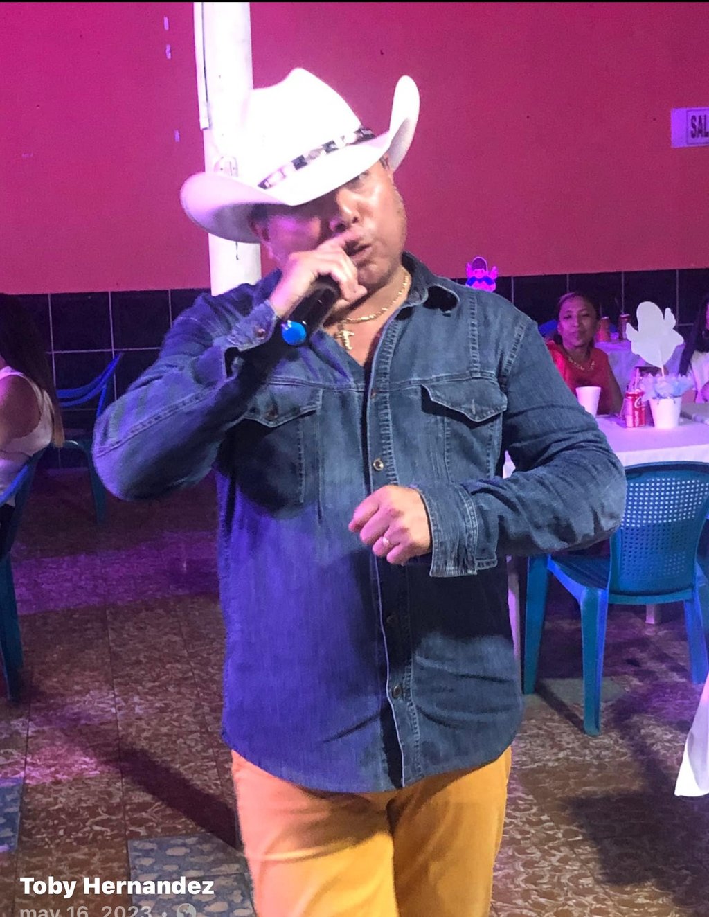 a man in a cowboy hat talking on a cell phone