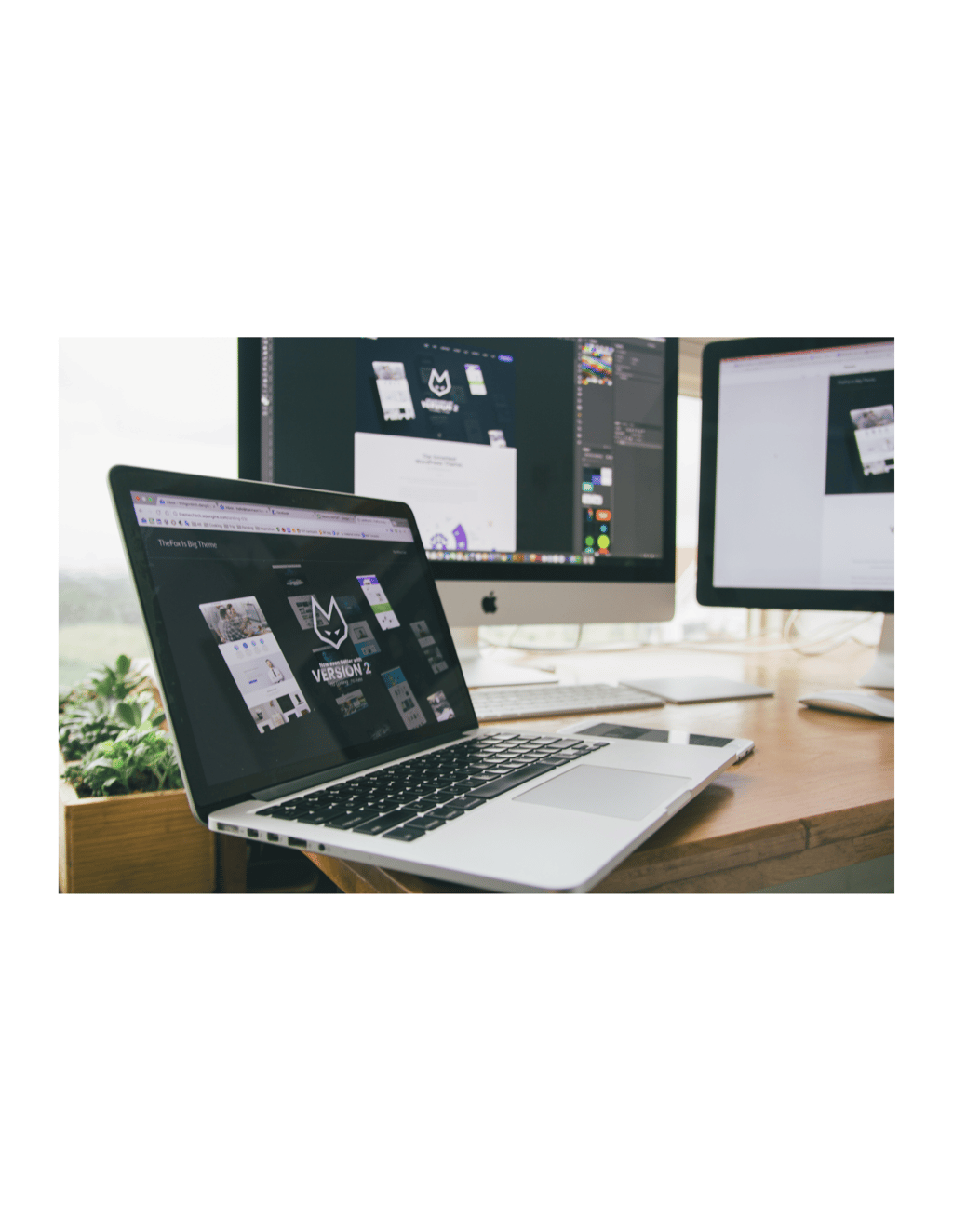 A pic of a laptop with two external monitors behind it