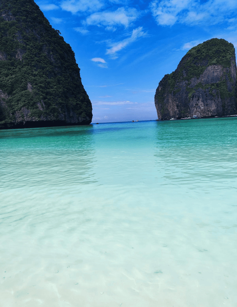 Kristallklares türkisfarbenes Wasser in der Maya Bay, Thailand, mit tropischen Kalksteinfelsen
