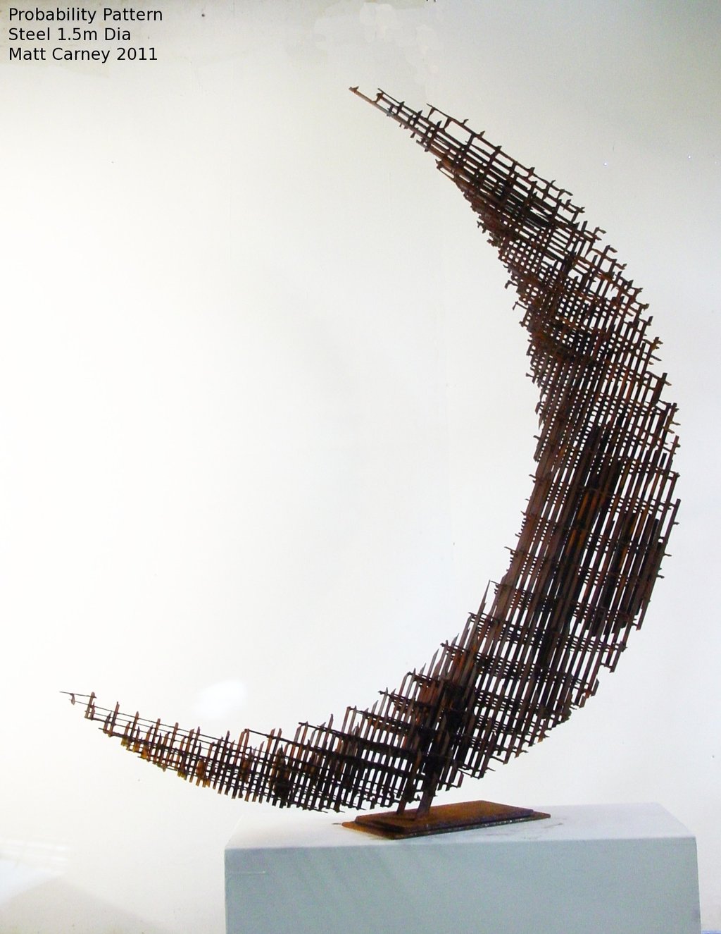 a rusted steel cross-hatched crescent shaped sculpture