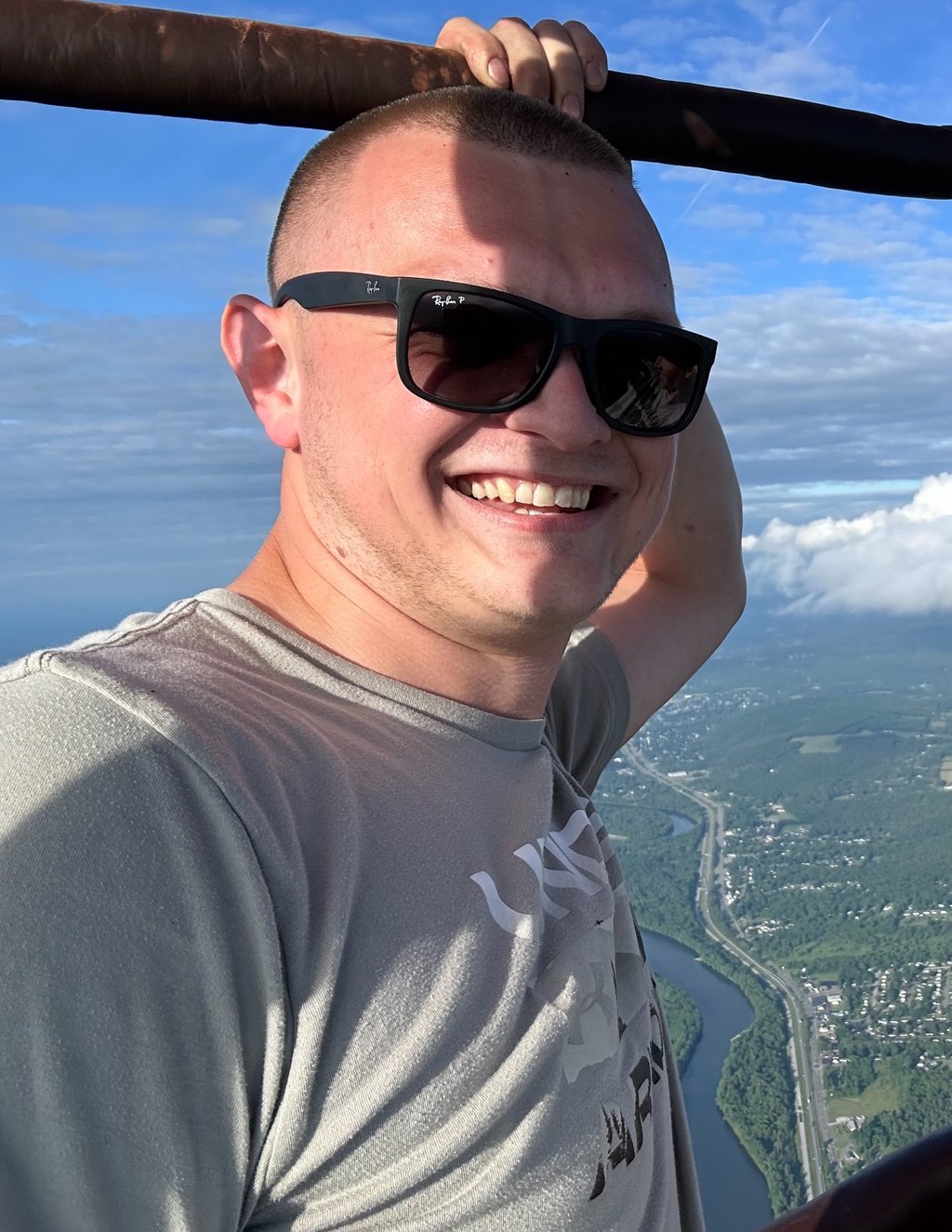 a man in sunglasses and sunglasses is smiling and holding a bat