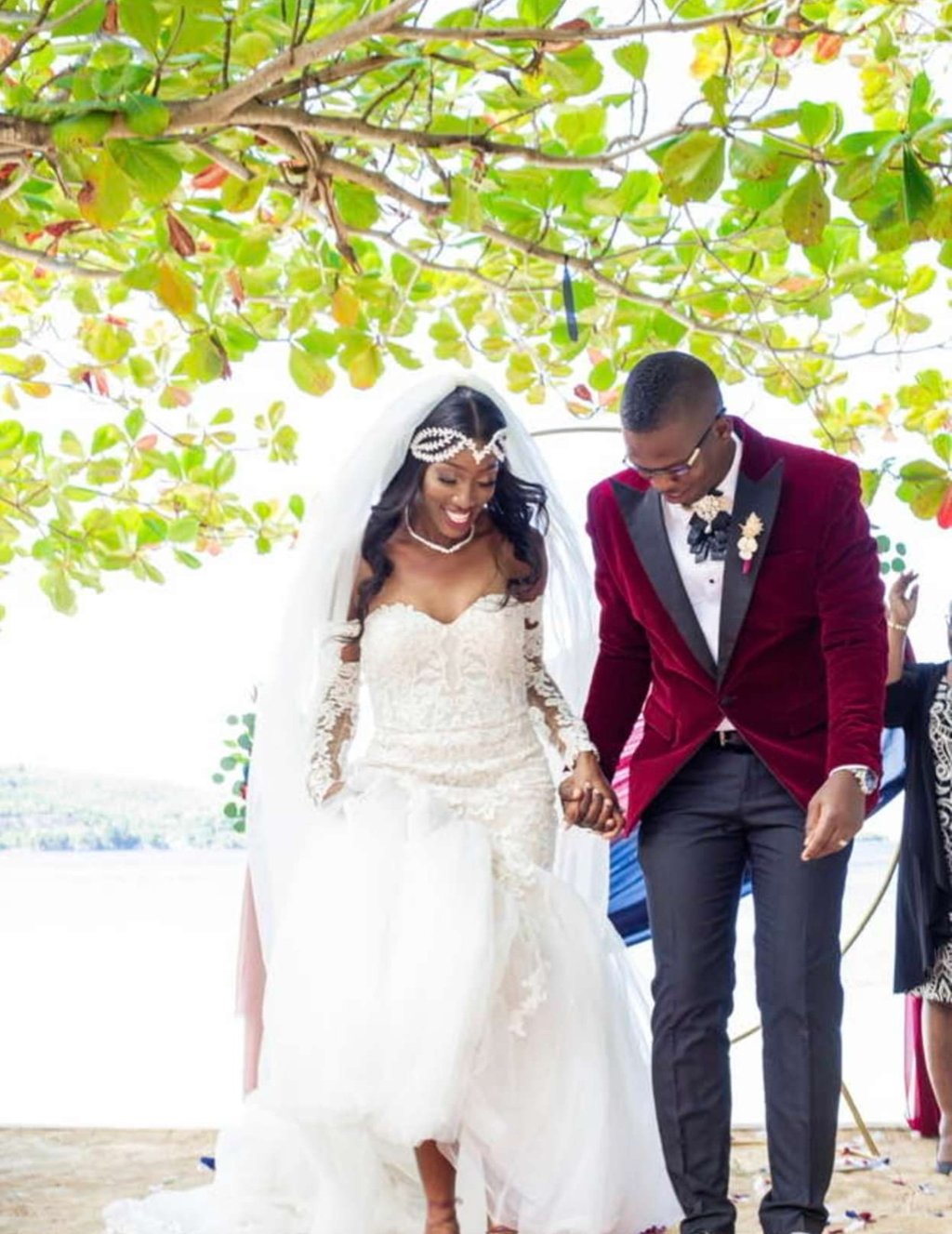 a bride and groom walking down the aisle of a beach wedding