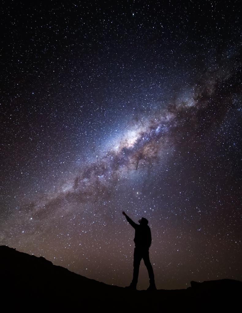 a person pointing at the stars in the sky