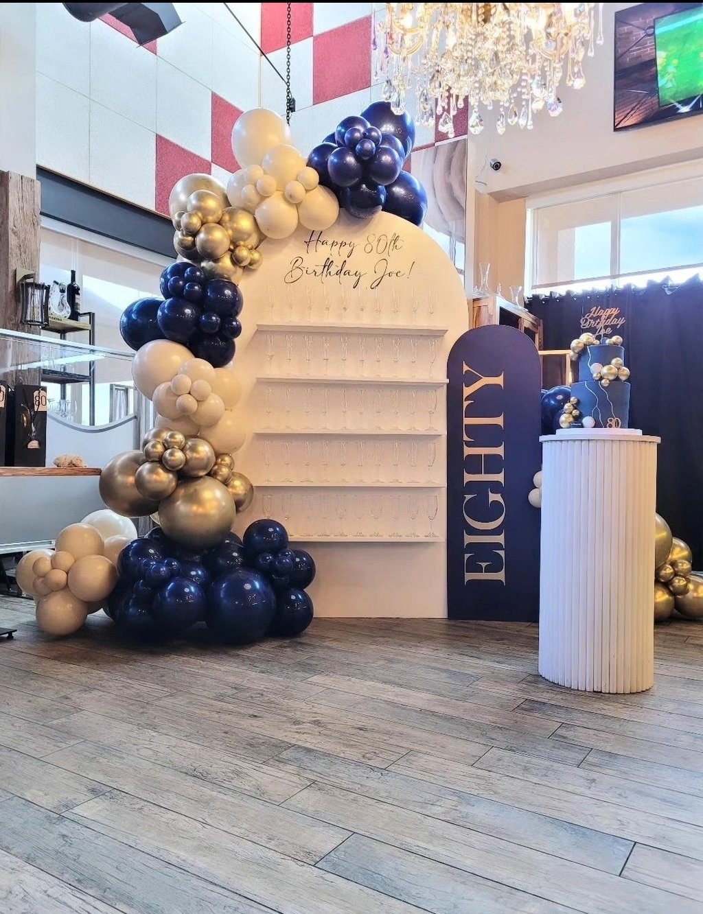 Balloon garland paired with our champagne/treat wall for an 80th birthday