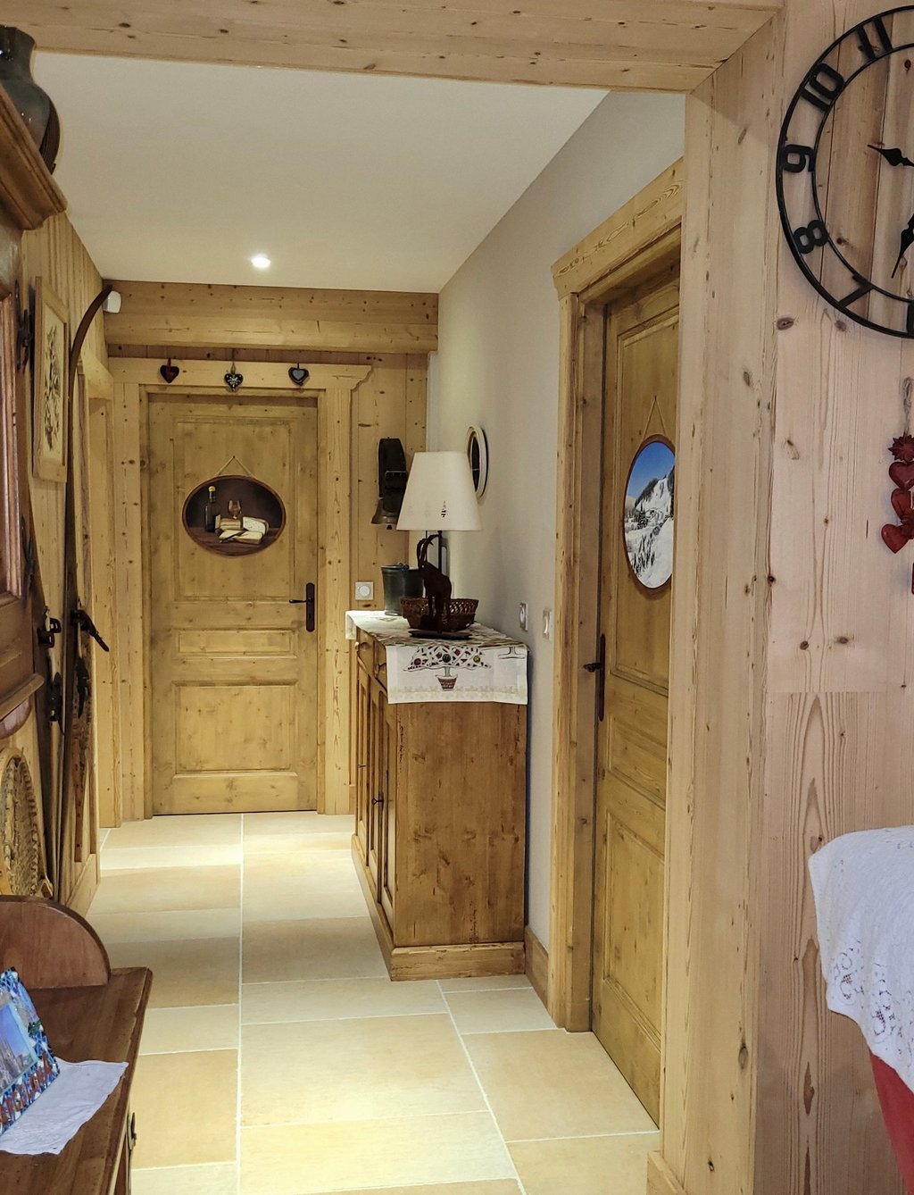 Intérieur d'un chalet dont les portes sont décorées de médaillons en trompe-l'oeil, thème jurassien.