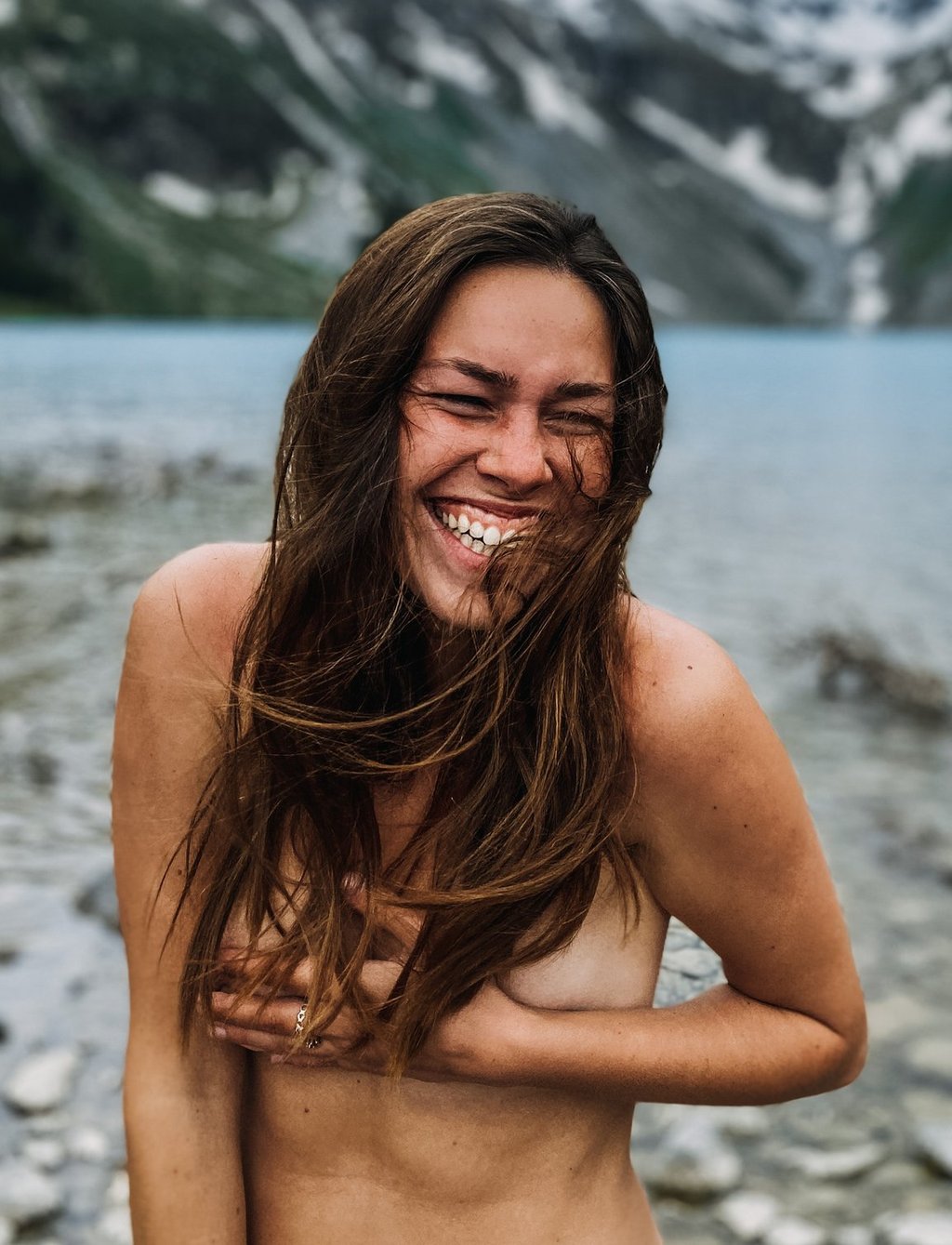 Nude woman smiling at a lake