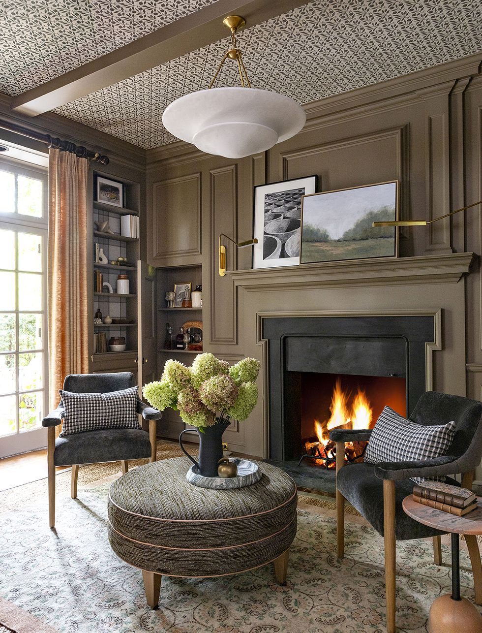 a living room with a fireplace and chairs