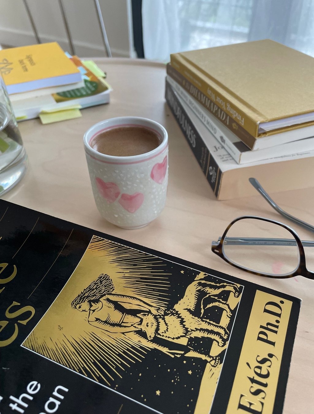 a cup of coffee and books on a table