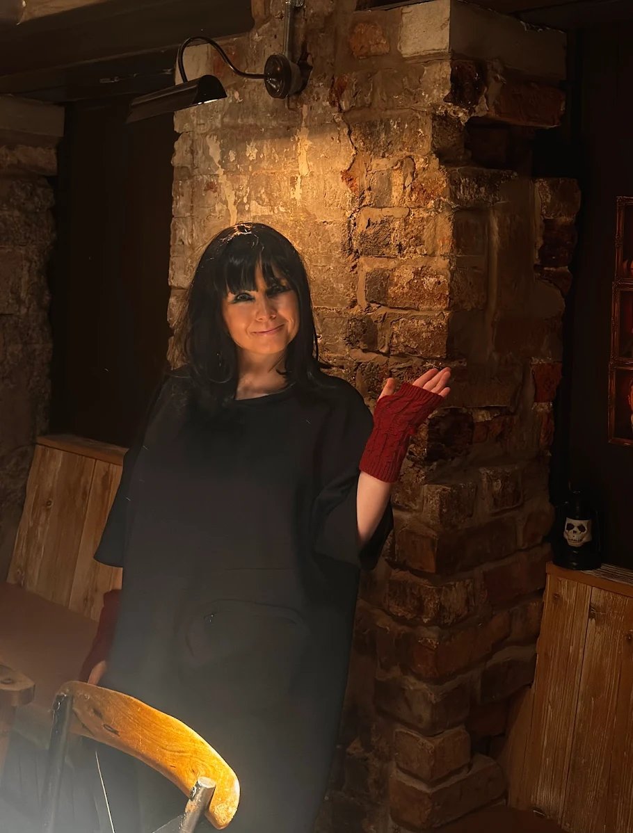 woman at Traitors event wearing a wig and red fingerless gloves.