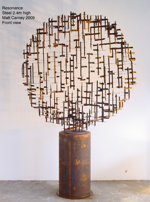 a rusted steel cross-hatched  circle sculpture on a rusted cylinder base 
