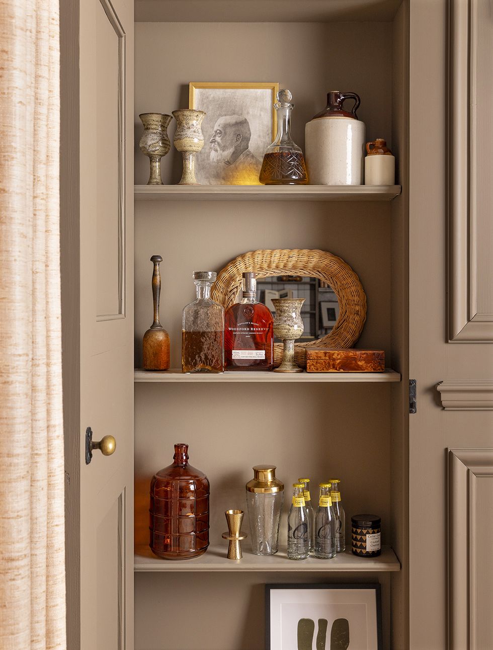 a cabinet with a shelf full of bottles and bottles