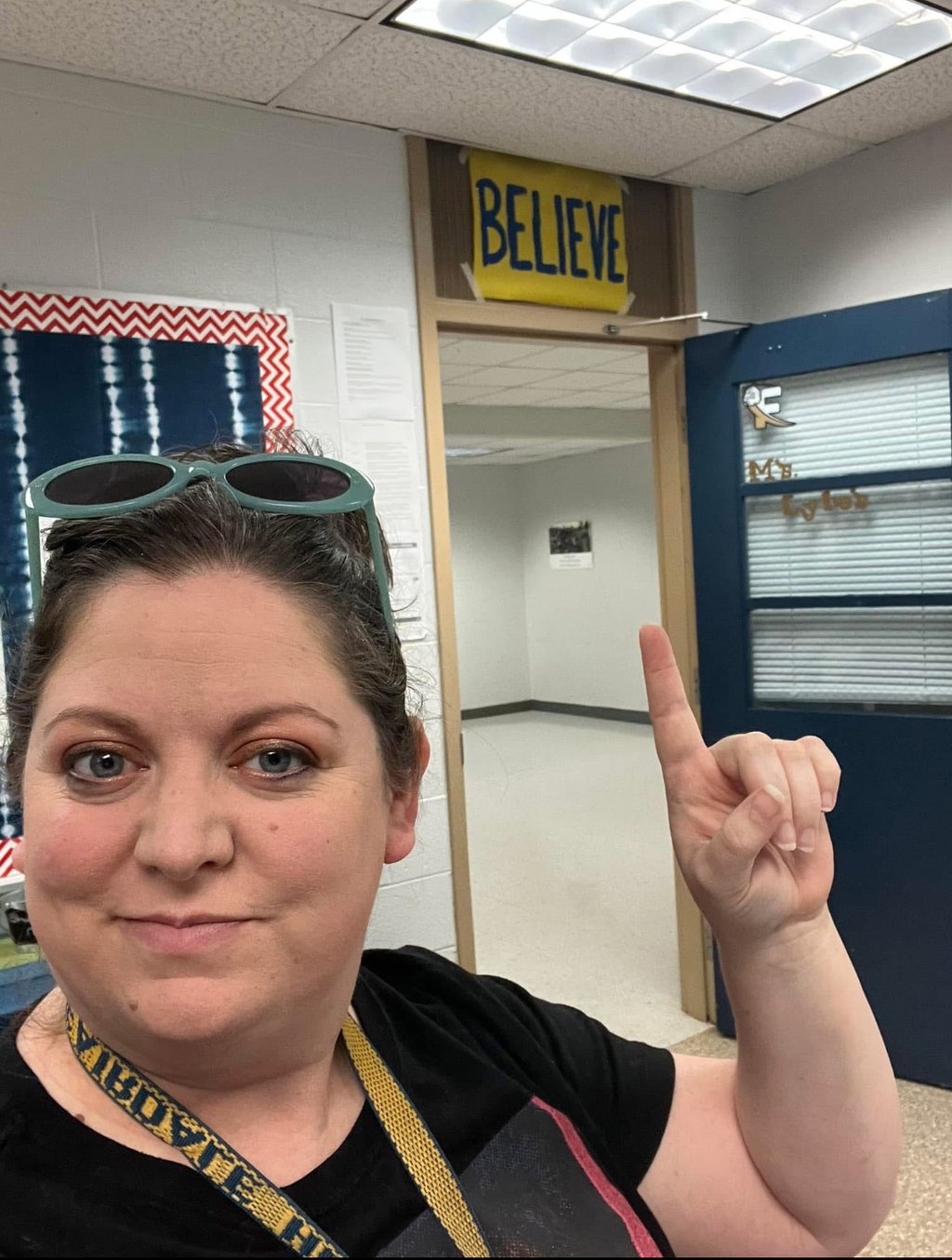 Woman with sunglasses standing in a classroom