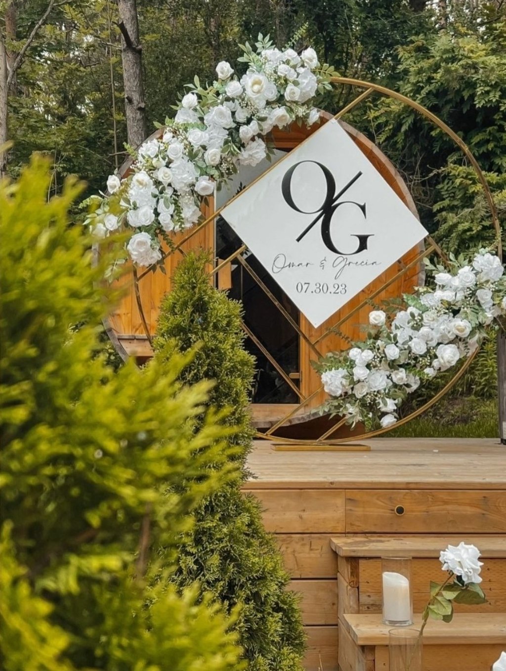 wedding ceremony gold chrome circle backdrop with white floral arrangements