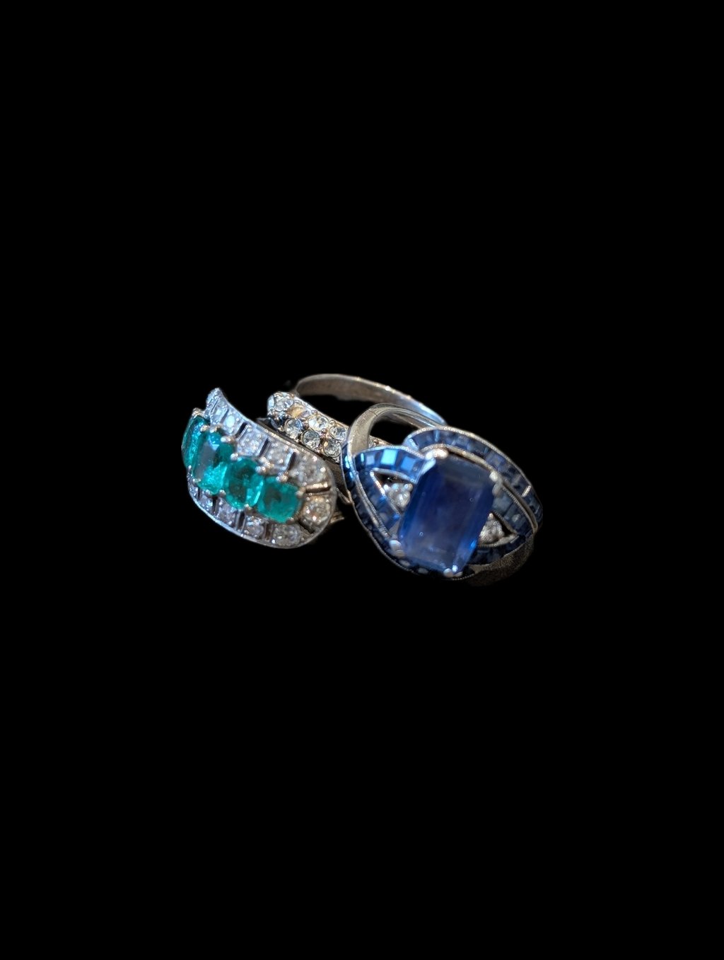 a pair of emerald diamond and sapphire rings