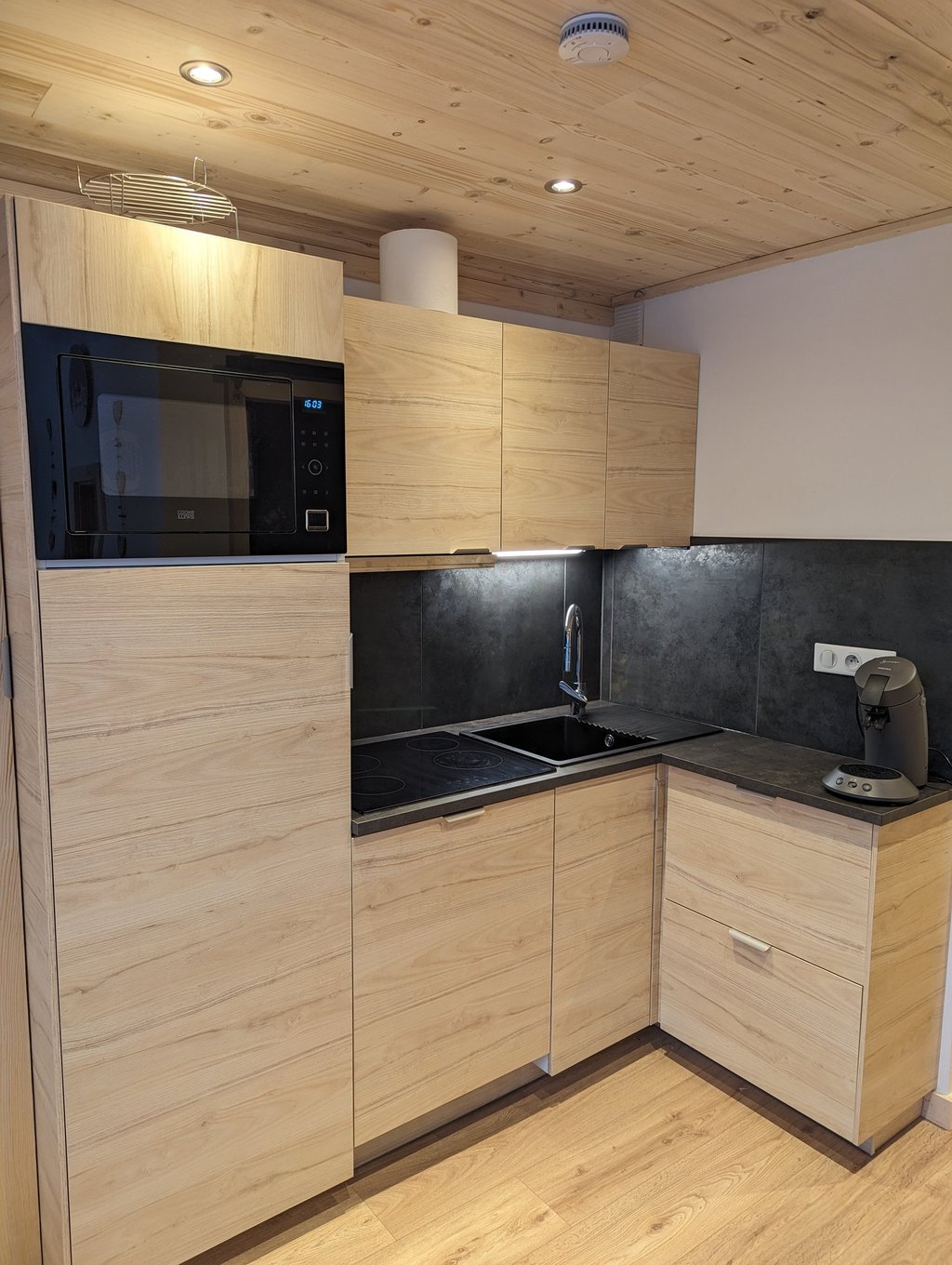 Fully equipped kitchen with oven, microwave combo and alpine wood interiors inside a Val Thorens ski apartment
