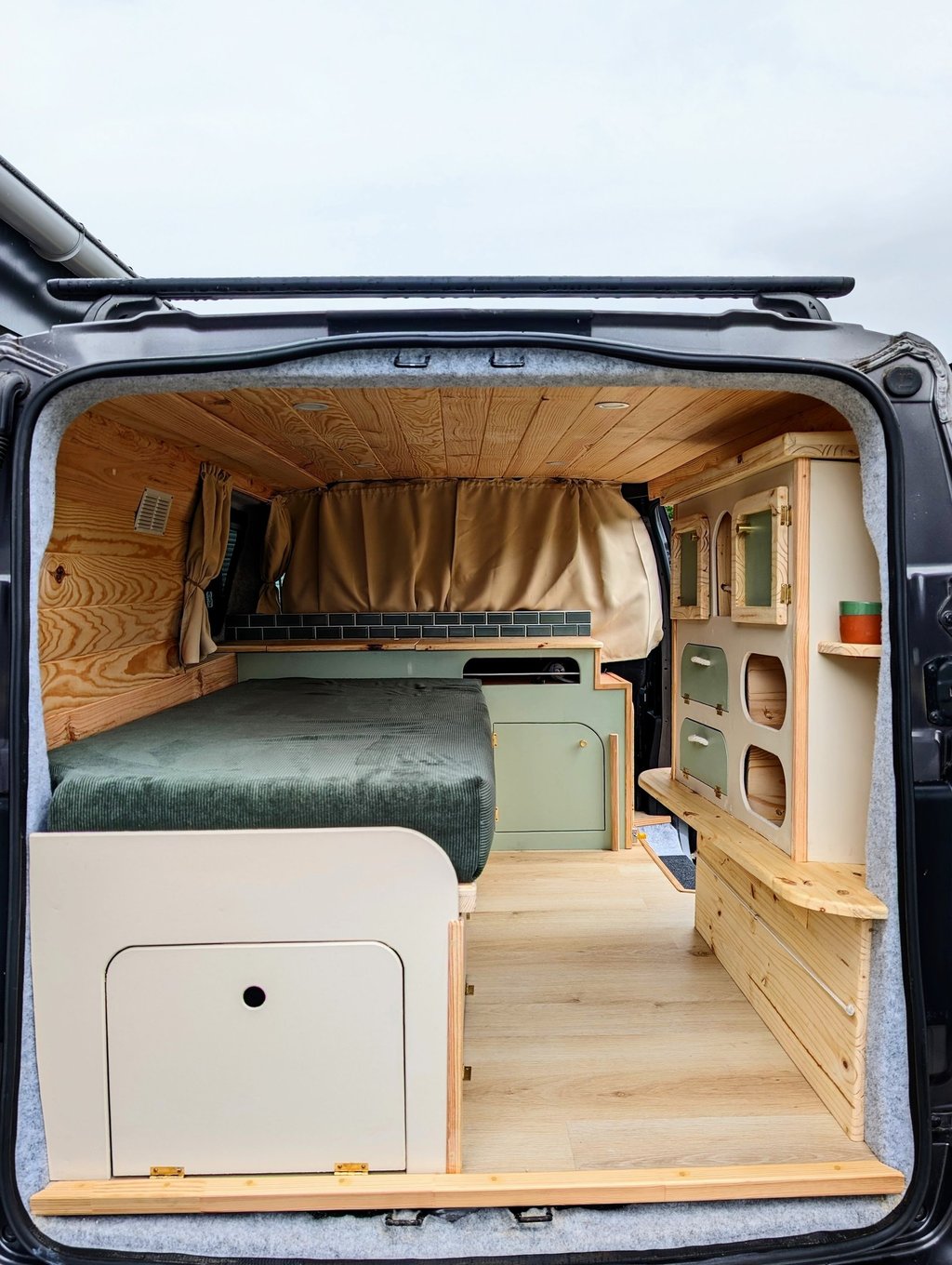 Aménagement intérieur van sur-mesure en bois clair avec lit peigne et rangements vintage par Pinbeur