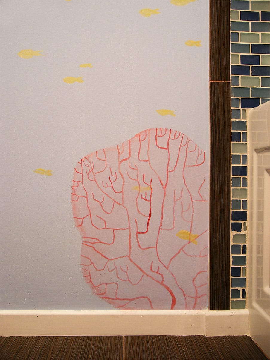 Hand-painted red coral and yellow fish painted in a contemporary style in a kid's bathroom.