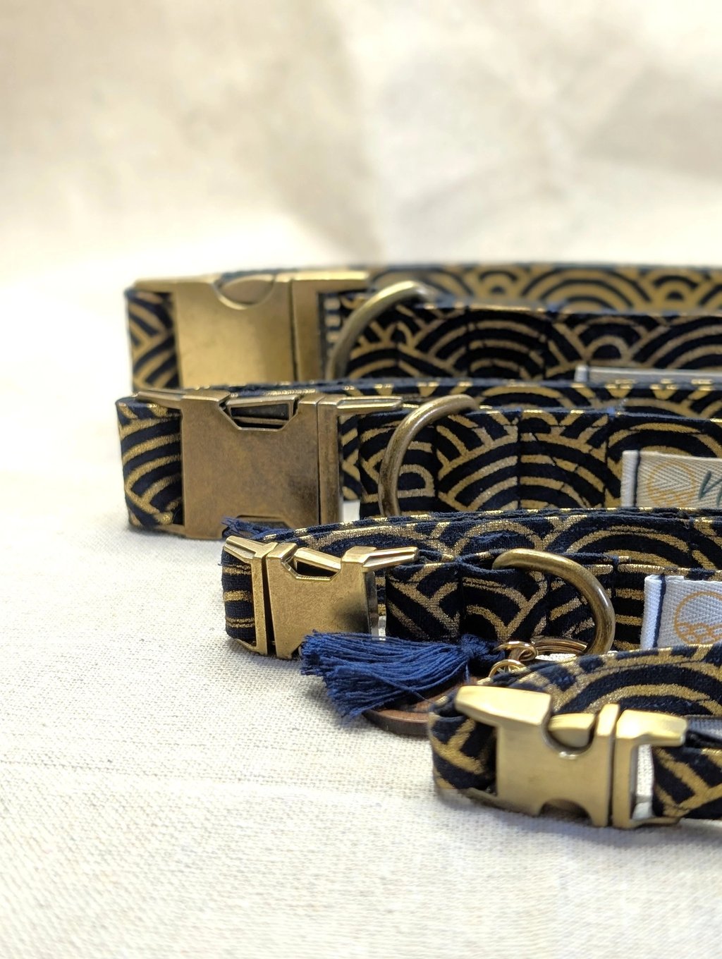 Elegant navy and gold wave pattern dog collars with brass buckles and tassels.