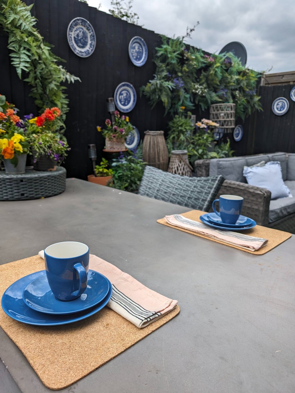 outdoor patio table with garden decor and wicker furniture.