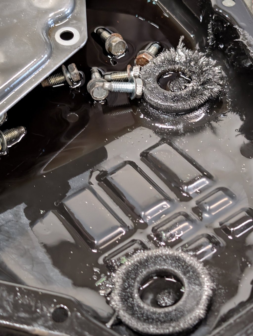 Metal shavings on transmission pan magnets during an oil change and gearbox inspection.