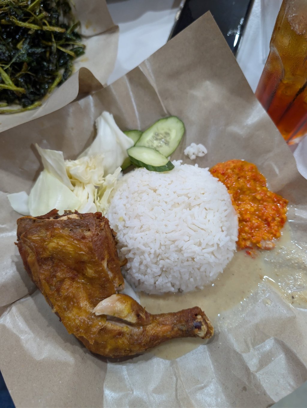 Malaysian ayam goreng fried chicken served with steamed rice, spicy sambal, and fresh vegetables.