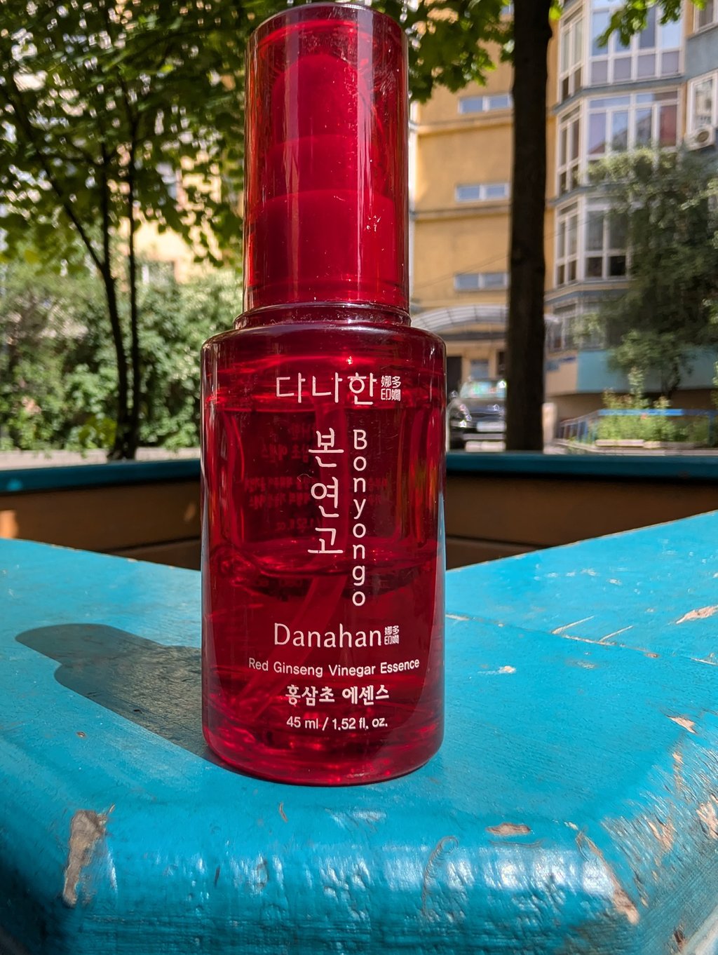 Danahan Bonyongo Red Ginseng Vinegar Essence in a red bottle on a blue wooden surface.