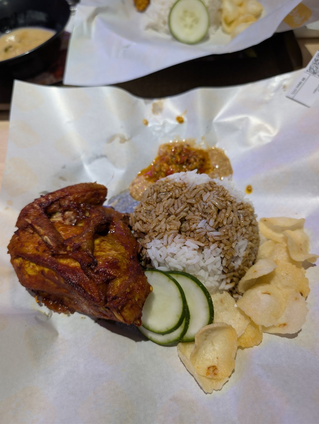 Malaysian Ayam Goreng fried chicken served with steamed rice, spicy sambal, and prawn crackers.