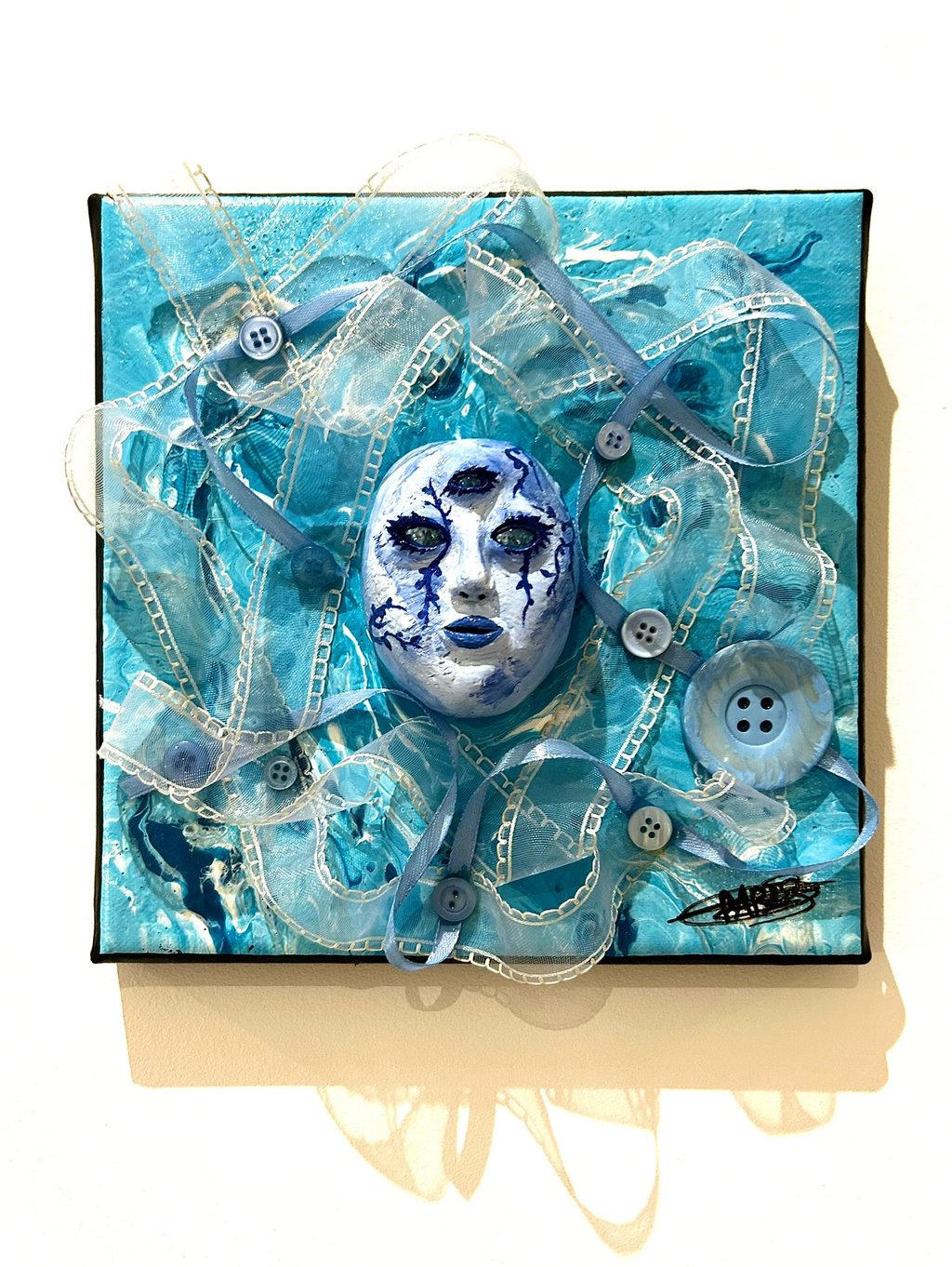 Ilona Paris tableau d'une sculpture d'un visage bleu avec trois yeux et du tissu autour