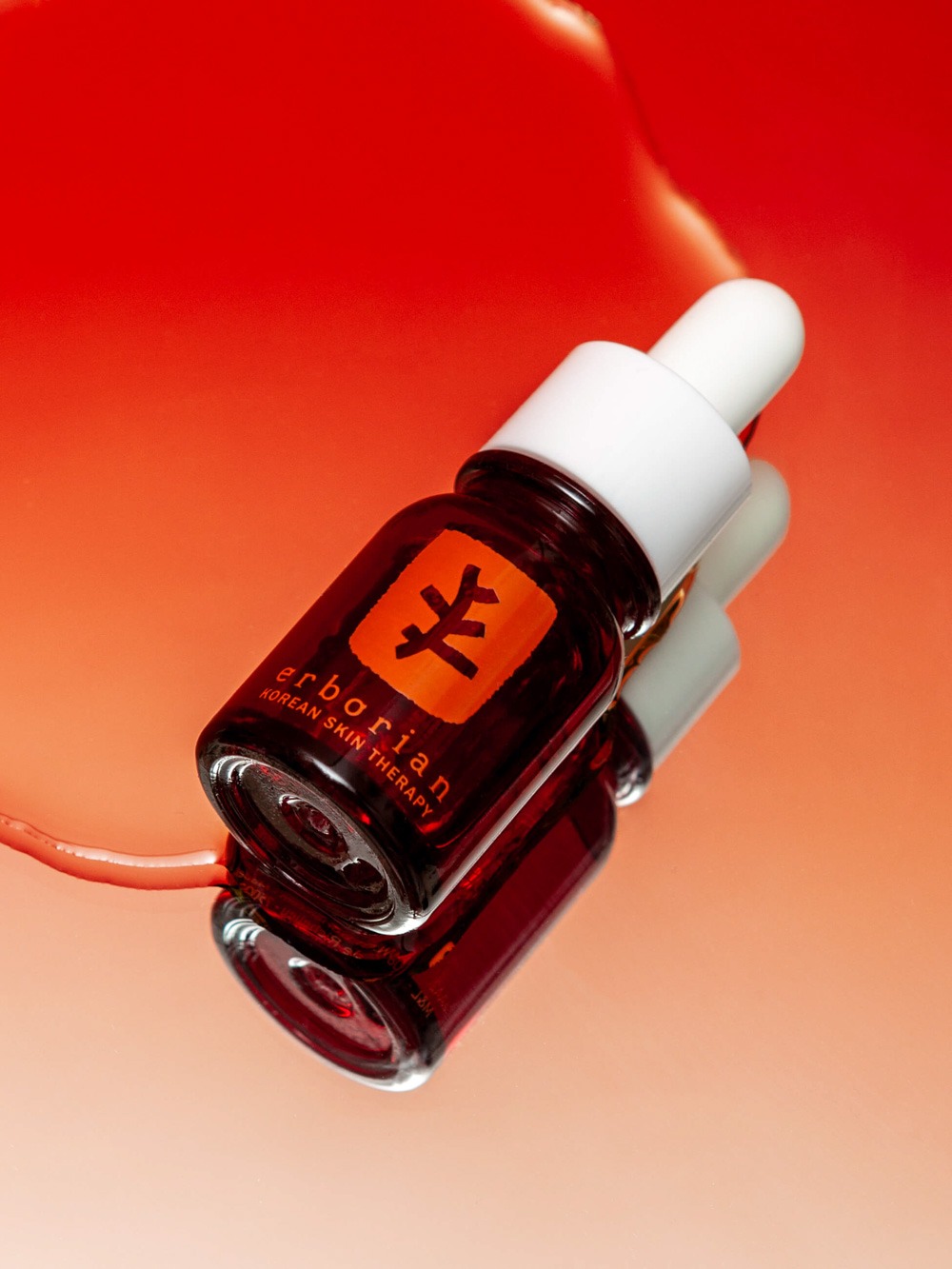 a bottle of cosmetic product in a red backgroud