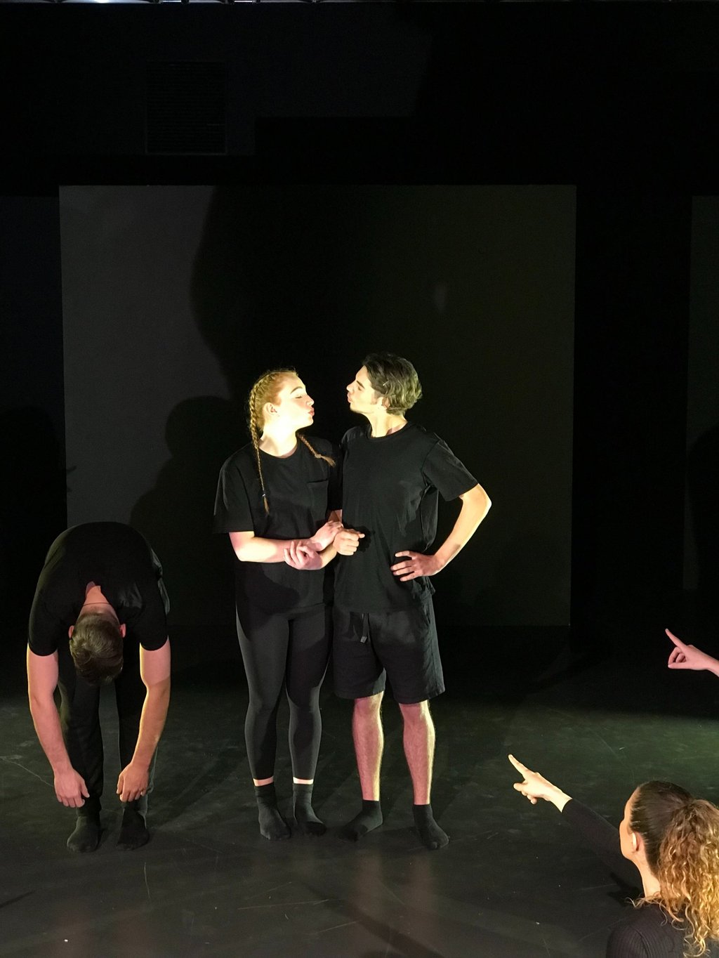 a group of people standing around a man in a black shirt