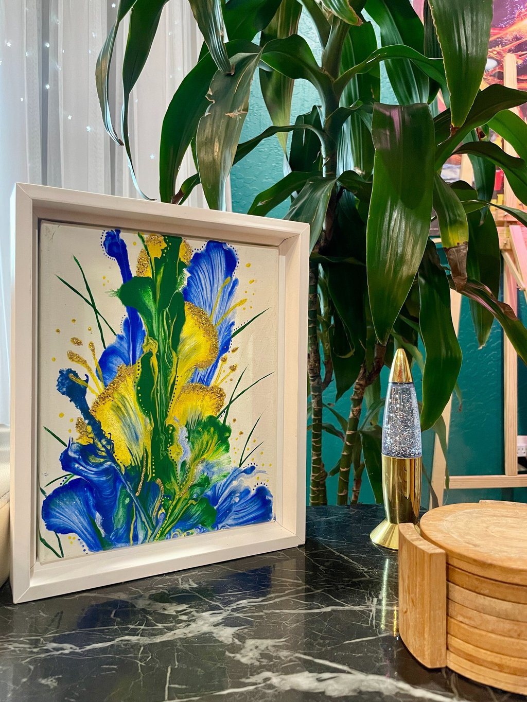 an abstract acrylic painting of green, yellow, and blue flowers home decor in a living room.