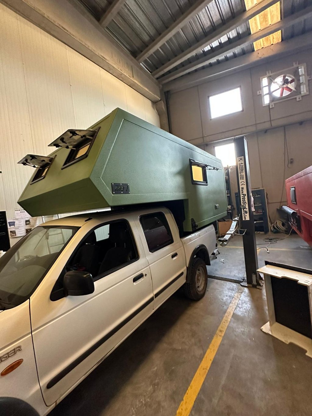 un vehículo pick up verde con cabina camper