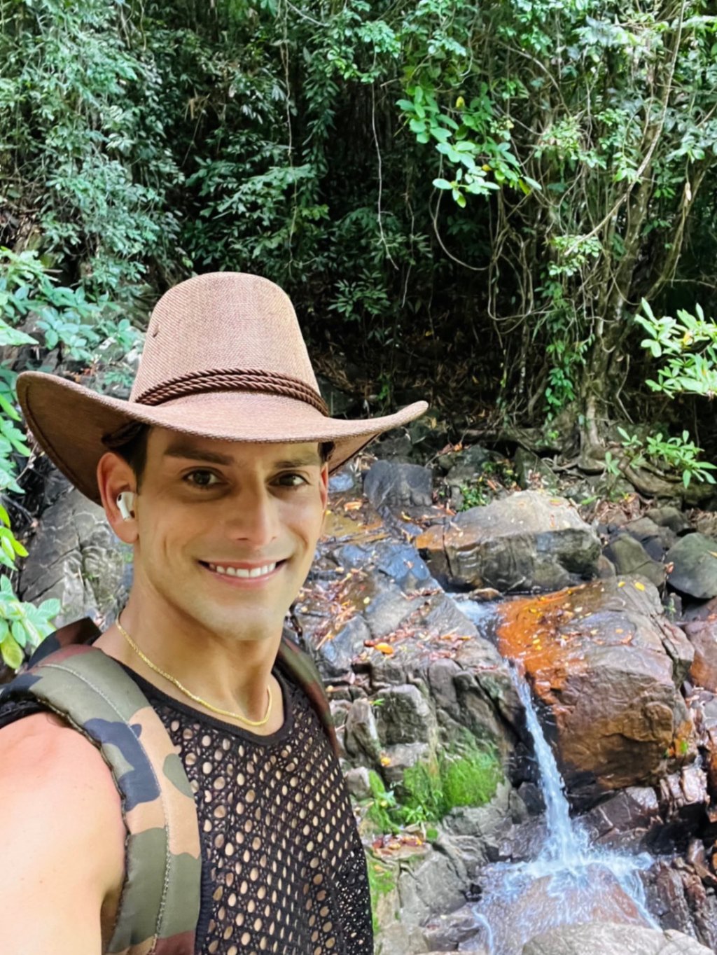 Travel writer Rick Silvia in the jungle in Thailand smiling in front of a small waterfall