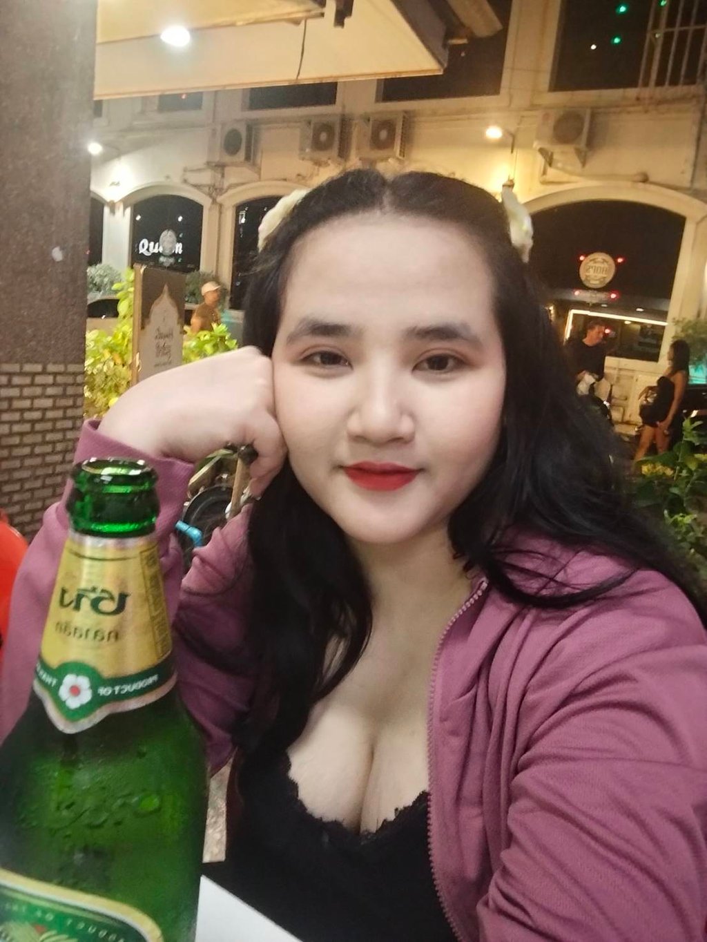 Lady therapist seated with fisted hand on cheek with a bottle of beer in front of her