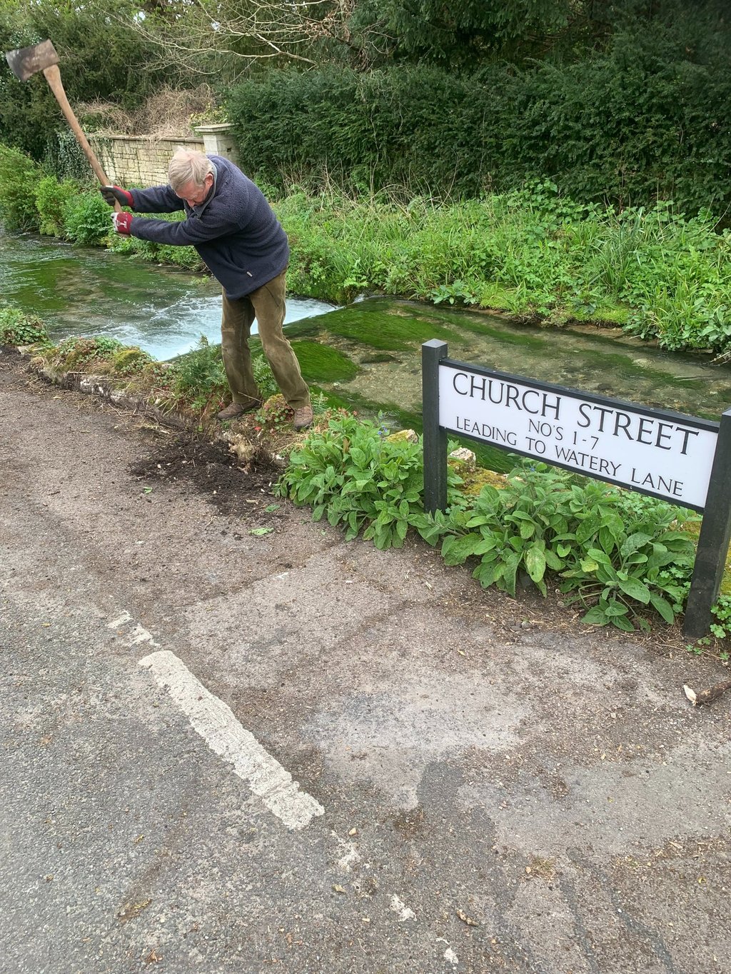 The Chairman of the River Wey Society clearing years of accumulated soil next to the wall 