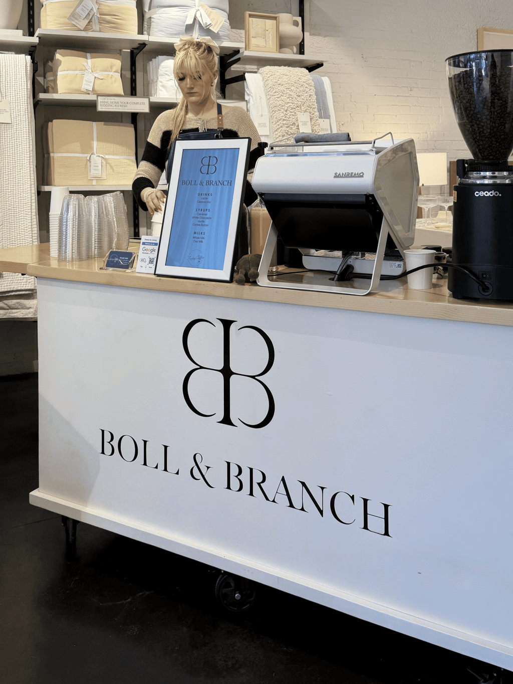 Barista preparing latte at custom branded mobile coffee cart for Boll & Branch corporate event in Dallas