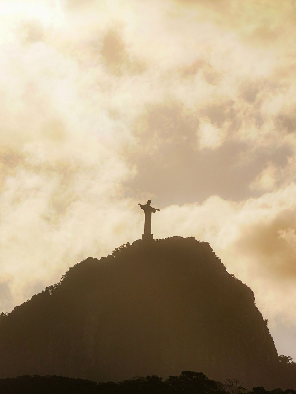 a statue of christ christ on a mountain top