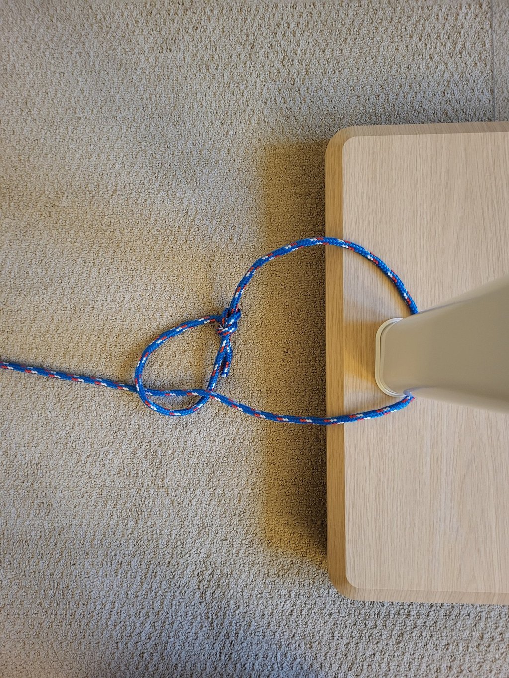 Running bowline knot tied around a vertical pole showing cinching action.
