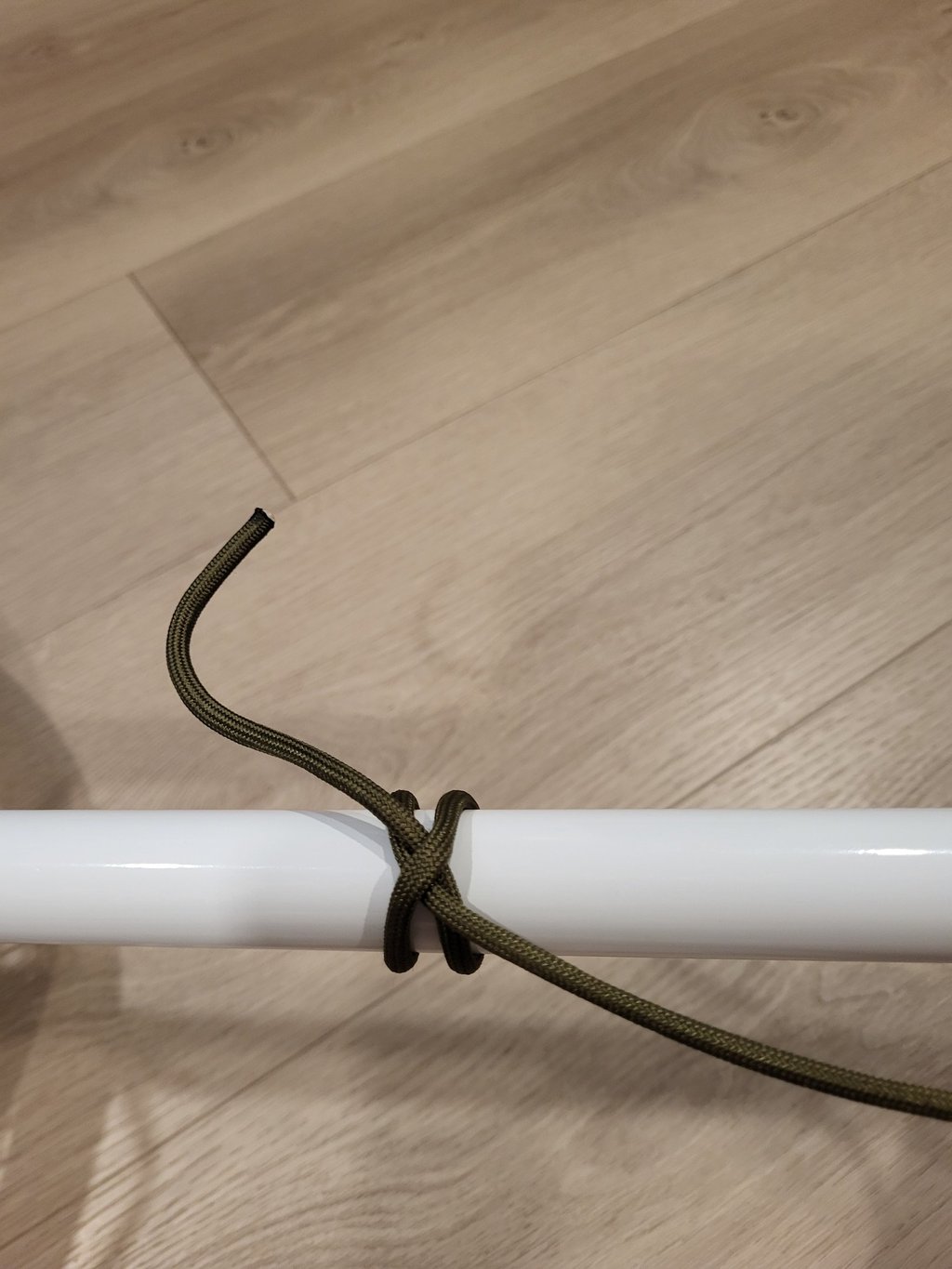 Clove hitch witb paracord, binding tightly to smooth painted pipe
