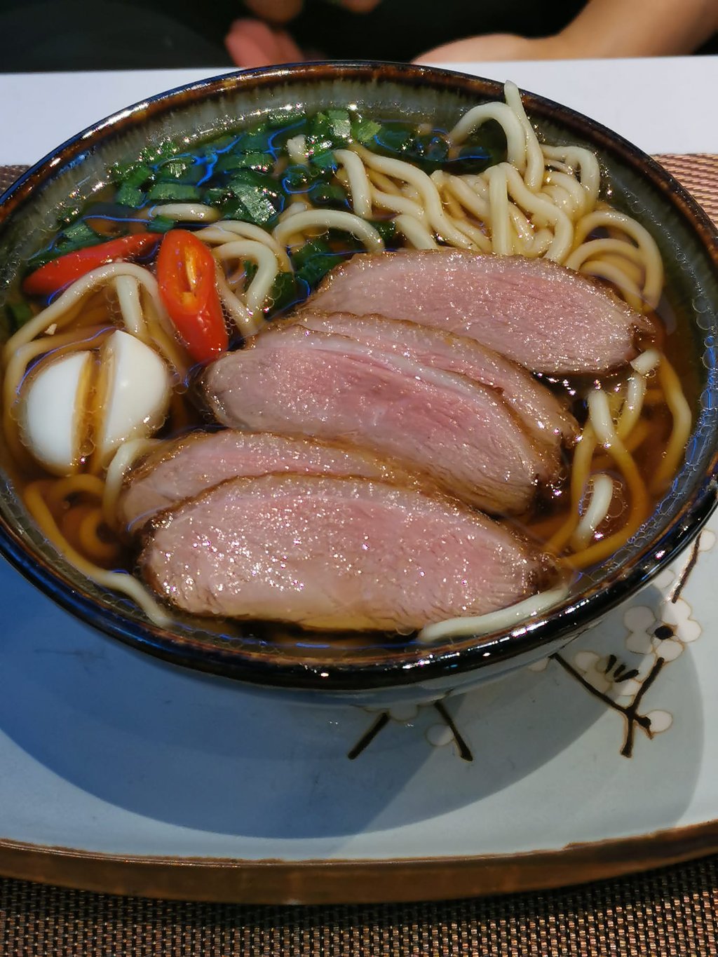 Duck Ramen mit Ente, Ei und Nudeln, unruhig und überladen fotografiert