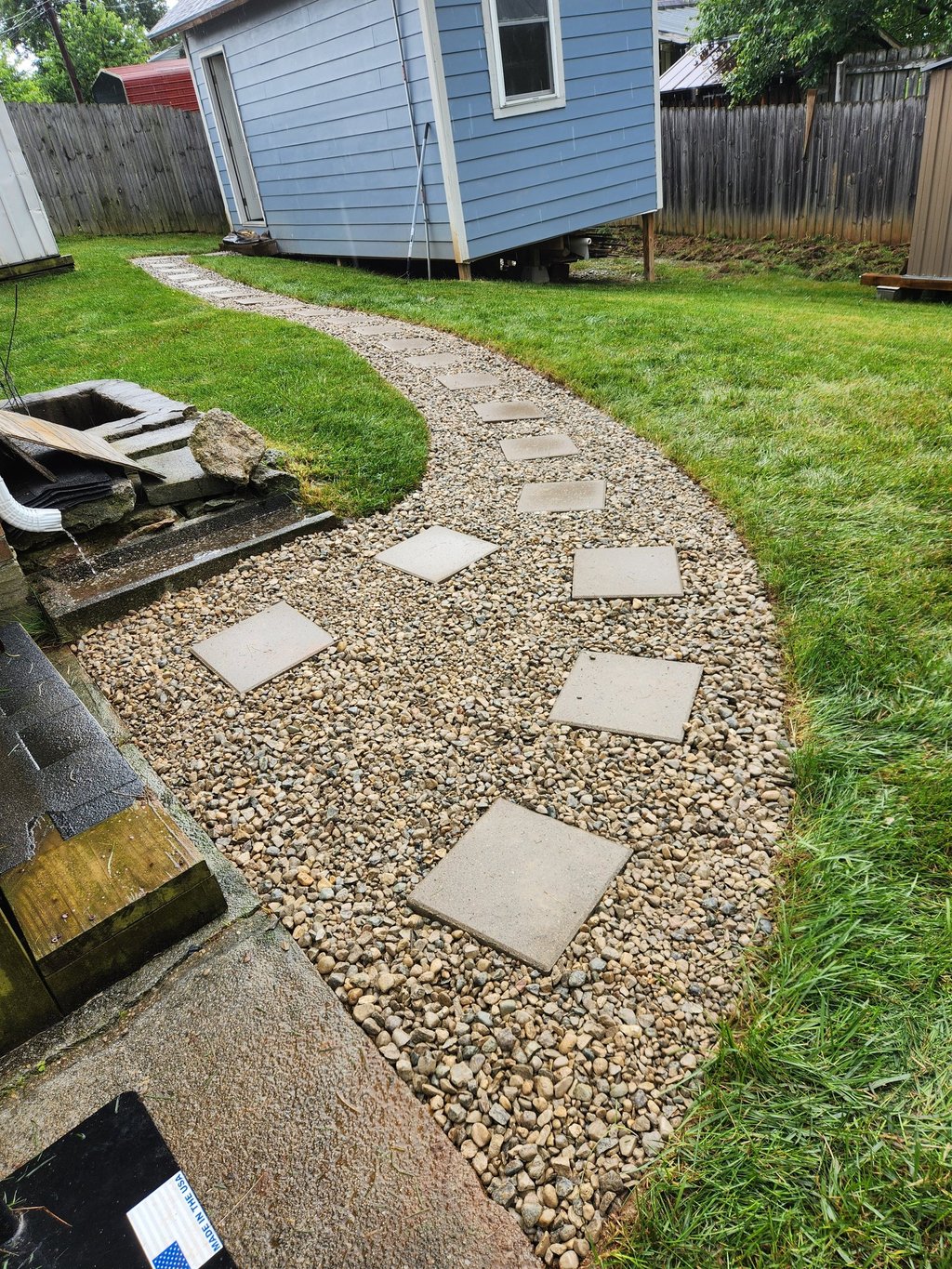 Gravel walkway with stepping stones installed in residential backyard