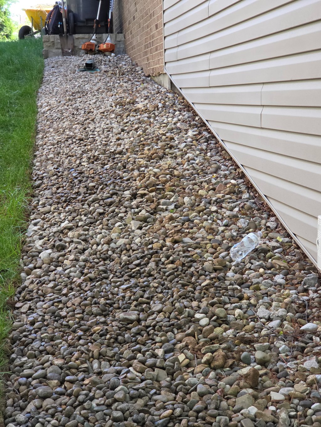 Gravel bed installed along house foundation for drainage and erosion control