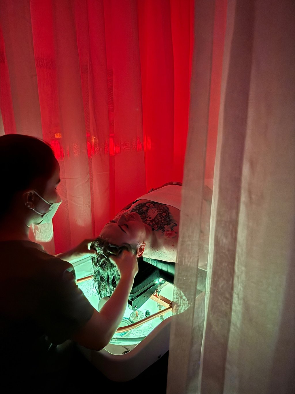 a woman in a mask massaging a head of a man