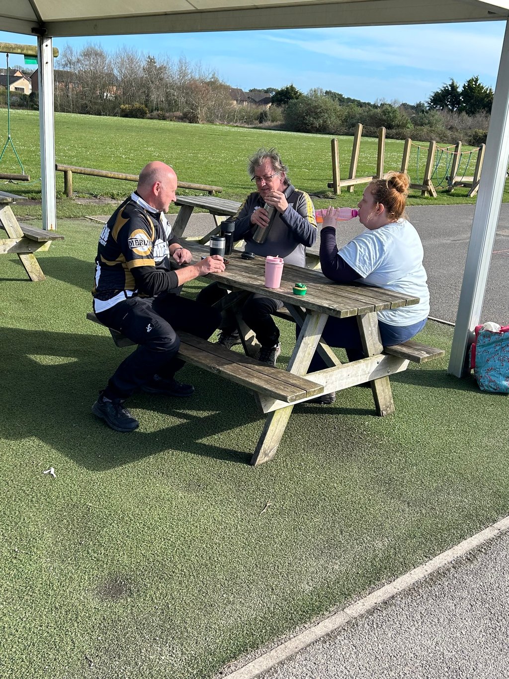 a group of archers having lunch at a picnic table