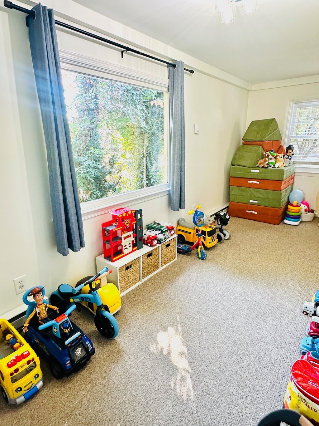 an organized playroom with a window and toys