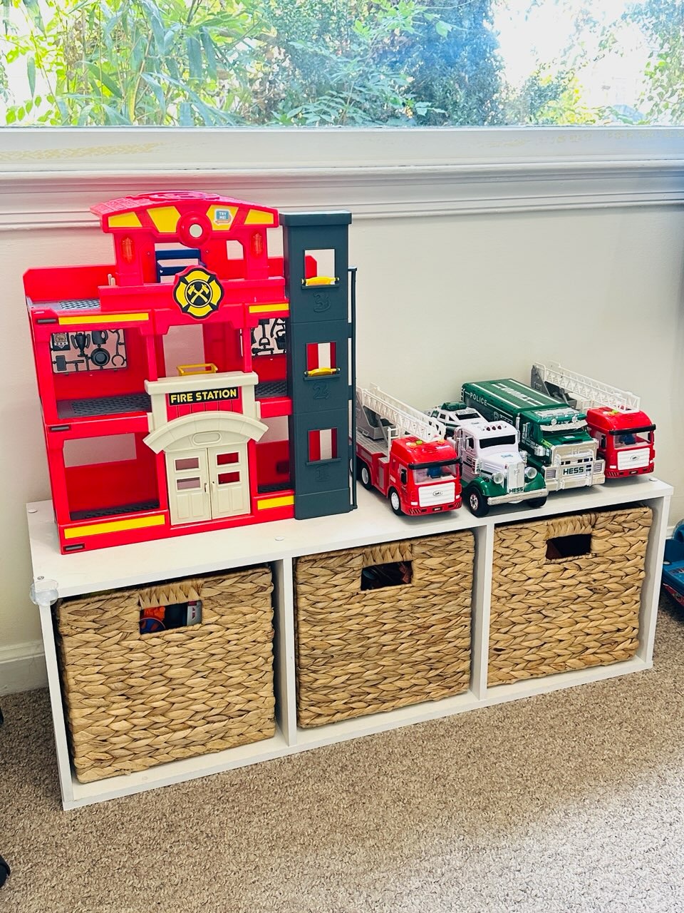 an organized shelving unit with bins and toys
