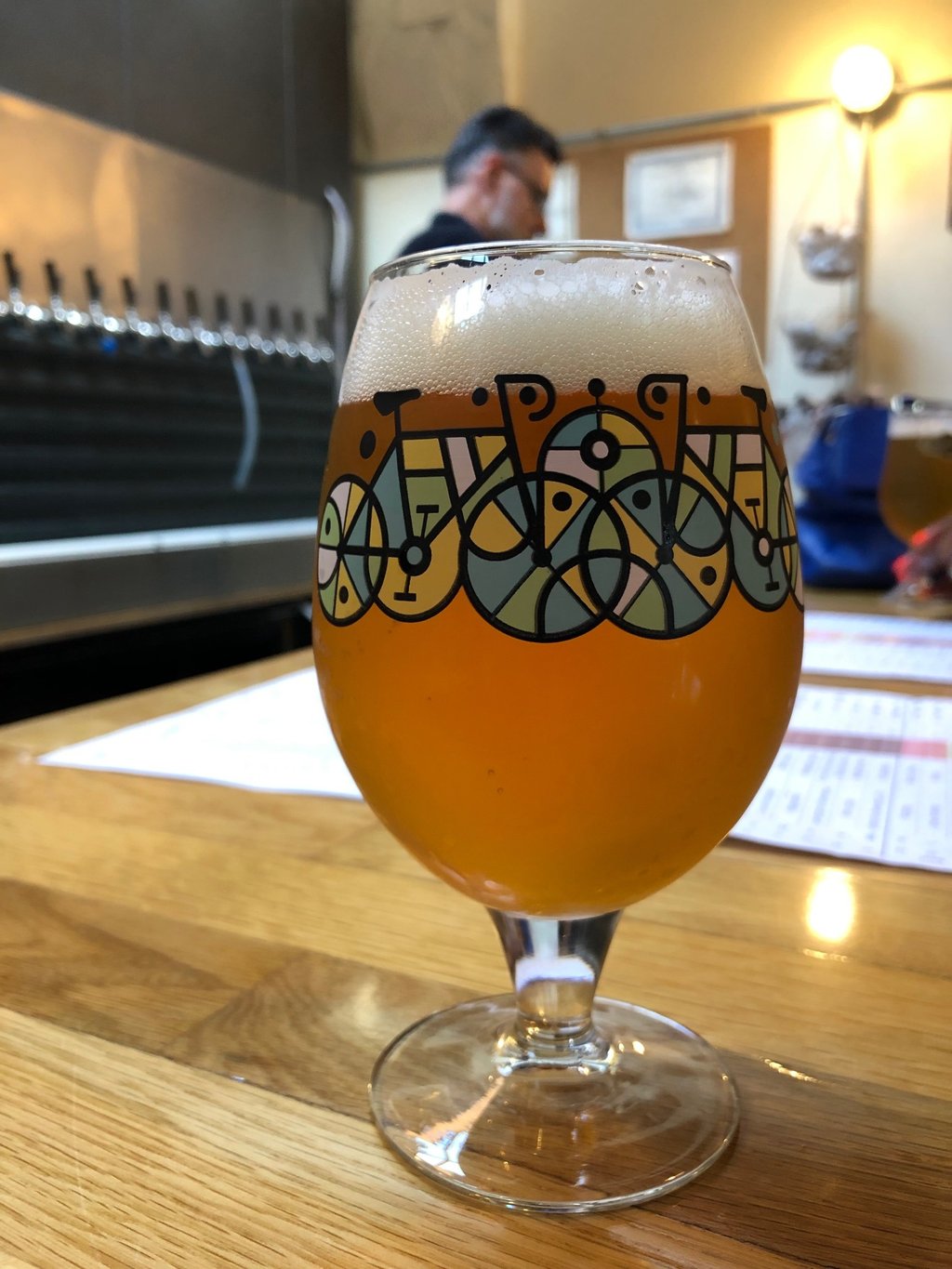 Craft beer in a tulip glass with bicycle art at a brewery taproom.