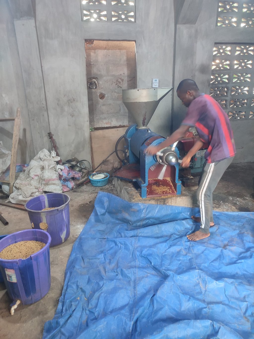 Les équipiers de l'association Emmaüs MOBOVOME pressent le soja torréfié